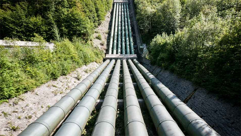 Multiple large pipelines descending through a forest corridor forming future hydrogen routes