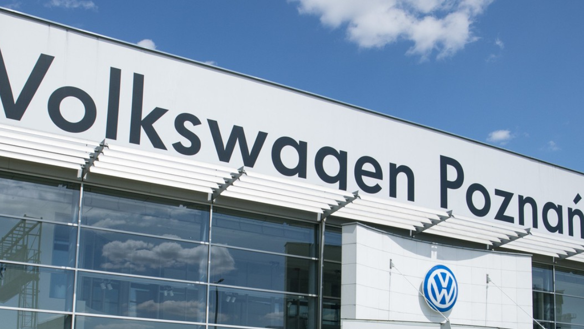 Volkswagen Poznań factory exterior with large signage and building facade under clear sky.