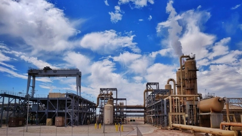 Industrial hydrogen facility with pipelines and processing units under a blue sky