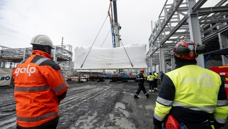 Workers install large industrial unit at refinery site