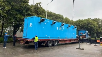 Blue HET modular container being delivered on a flatbed truck