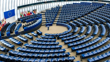 Empty European Parliament hemicycle chamber with EU flag displayed